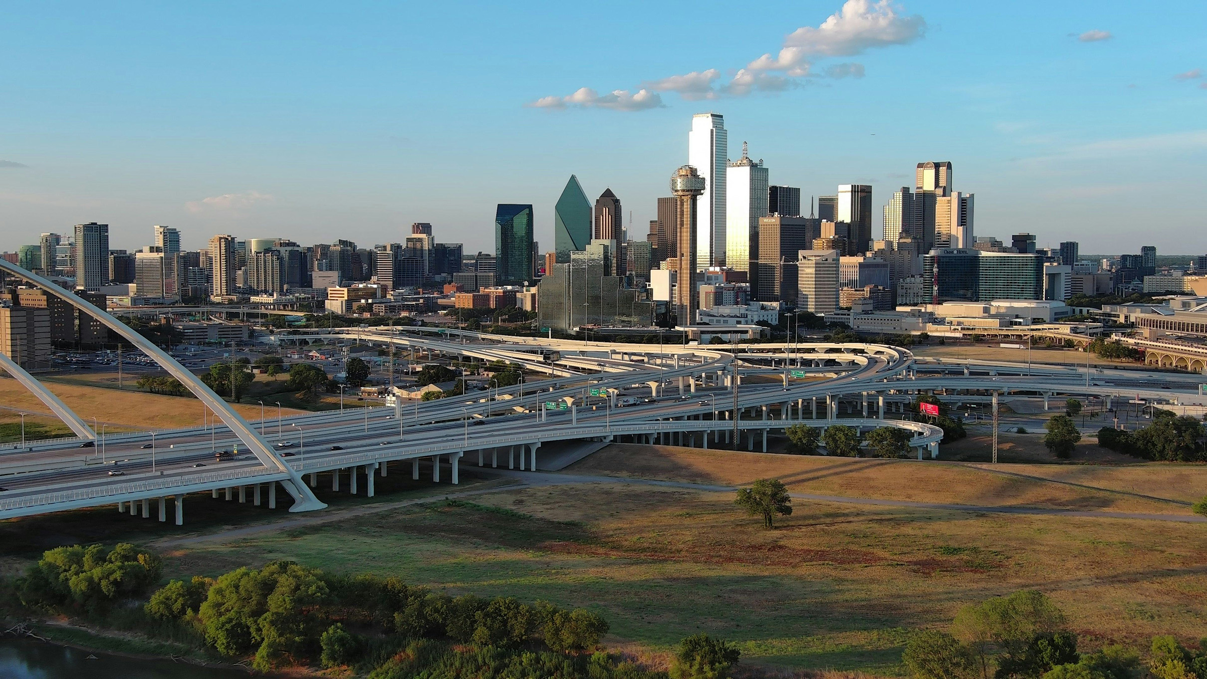 Aerial view of Dallas skyline and highway interchange at golden hour